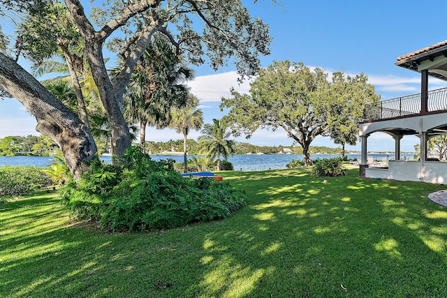 view of yard with a balcony and a water view