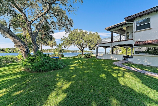 view of yard with a balcony and a water view