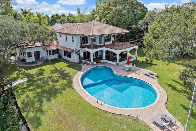 view of pool with an outdoor fire pit, a lawn, and a patio