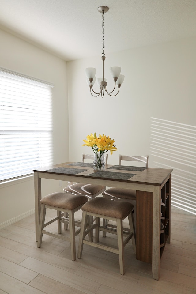 dining room with hardwood / wood-style floors and a chandelier