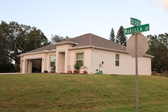 view of side of property with a garage and a lawn