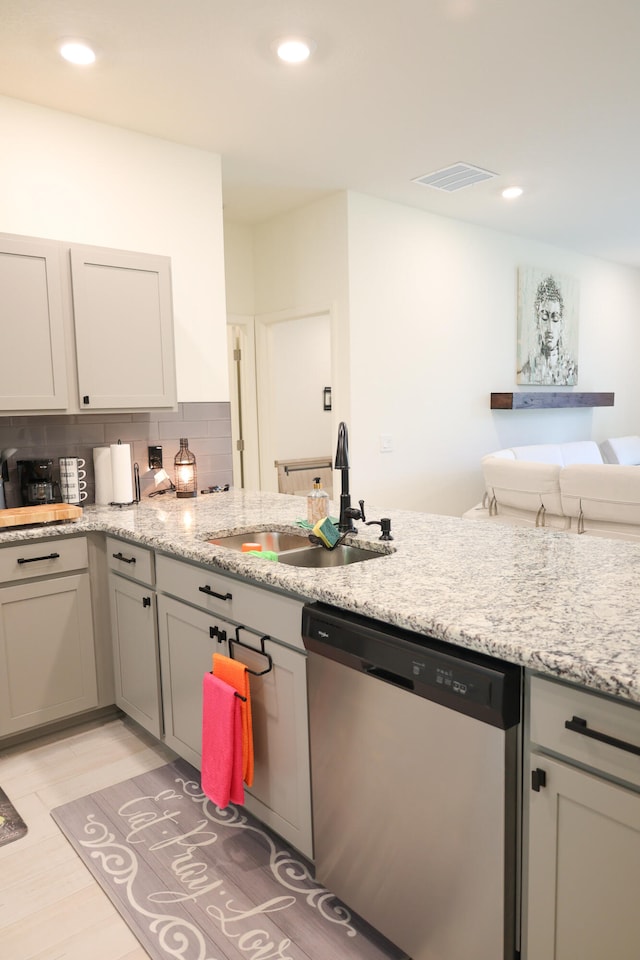 kitchen featuring gray cabinetry, light stone countertops, sink, backsplash, and stainless steel dishwasher