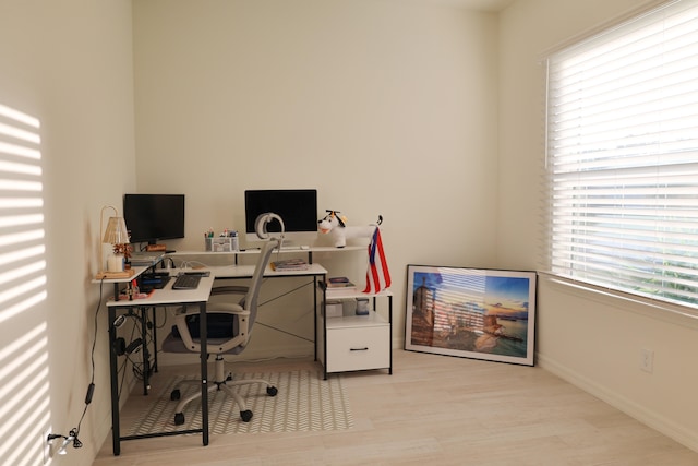 office with light hardwood / wood-style floors and a healthy amount of sunlight