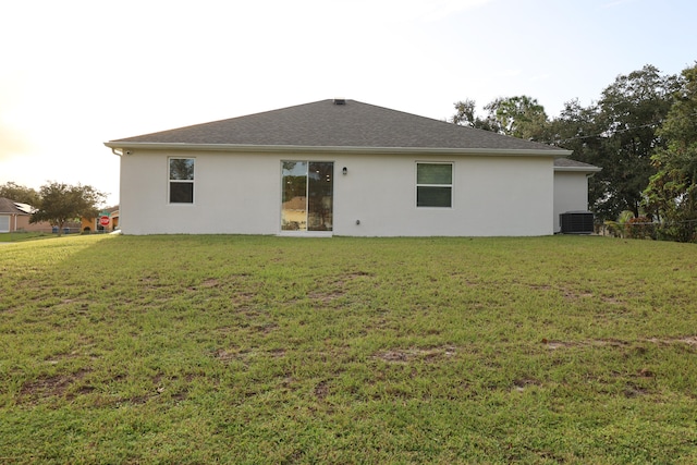 back of property featuring a lawn and central AC unit