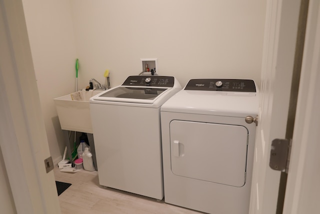 laundry room featuring light hardwood / wood-style floors and washing machine and dryer