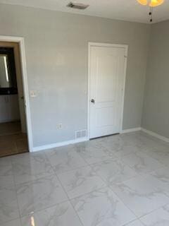 136 SW Peacock Blvd Unit 19-204, Port Saint Lucie, FL 34986 - unfurnished bedroom featuring marble look tiles, baseboards, and a closet