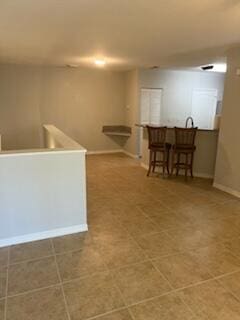 136 SW Peacock Blvd Unit 19-204, Port Saint Lucie, FL 34986 - kitchen featuring baseboards, a kitchen breakfast bar, and tile patterned flooring