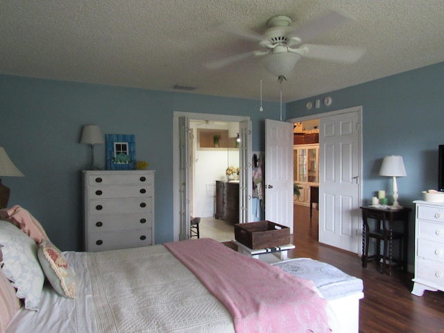 bedroom featuring dark hardwood / wood-style floors, a textured ceiling, and ceiling fan