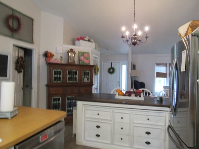 kitchen with a notable chandelier, white cabinets, and stainless steel appliances