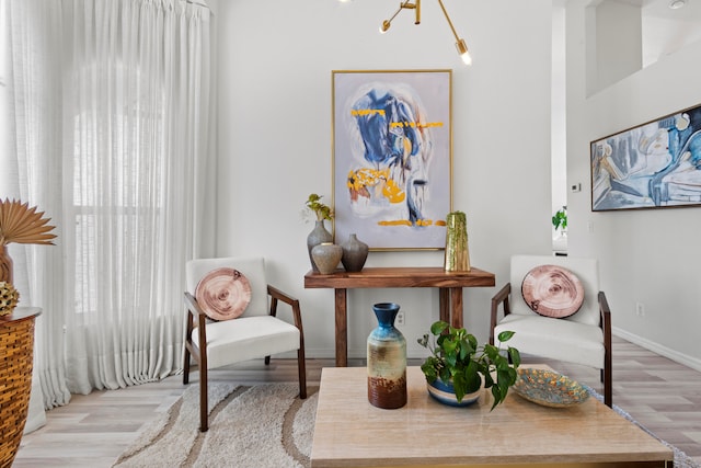 living area featuring light hardwood / wood-style flooring and a notable chandelier