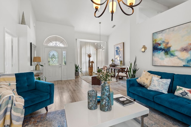 living room featuring a chandelier, high vaulted ceiling, and light wood-type flooring