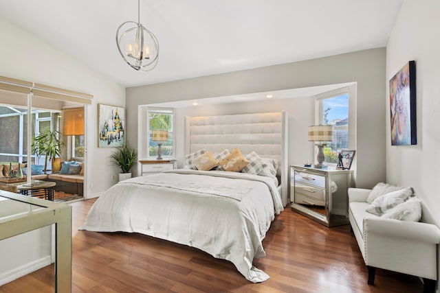 bedroom with a chandelier, dark wood-type flooring, and vaulted ceiling