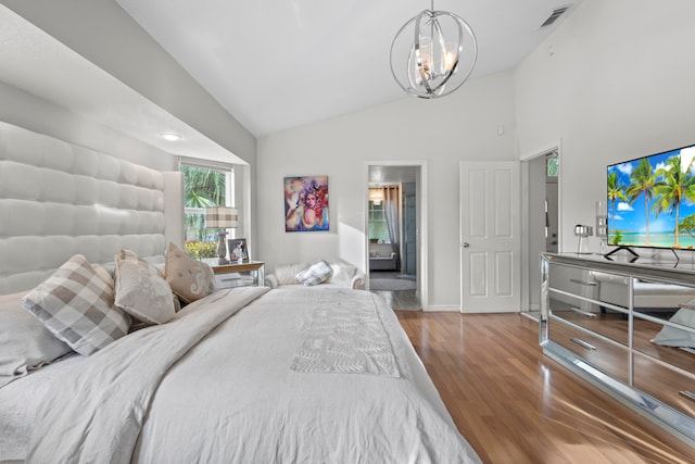 bedroom featuring an inviting chandelier, lofted ceiling, and hardwood / wood-style floors