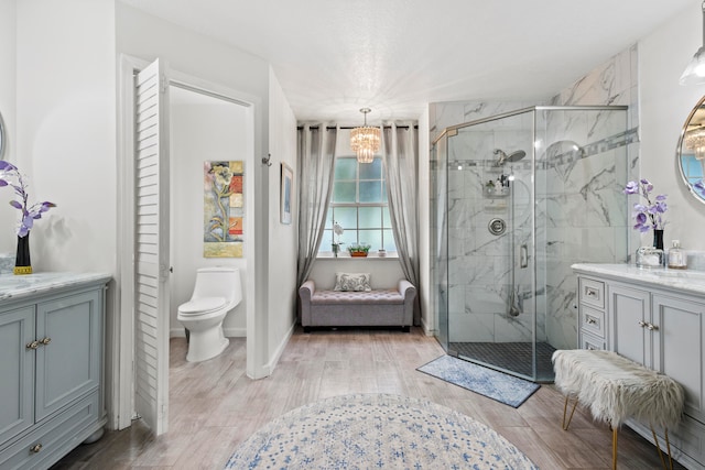 bathroom featuring toilet, an enclosed shower, hardwood / wood-style flooring, and vanity