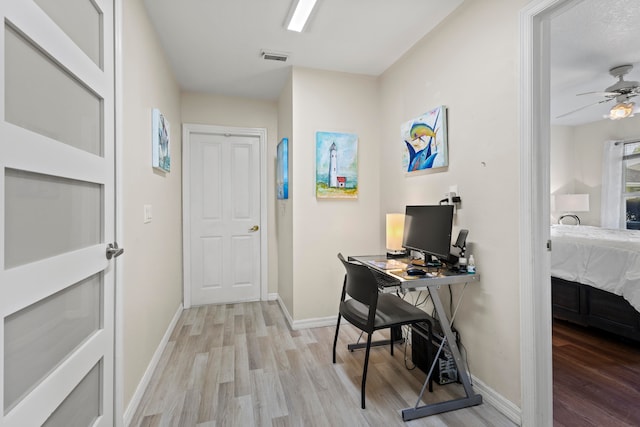 home office featuring light hardwood / wood-style flooring and ceiling fan