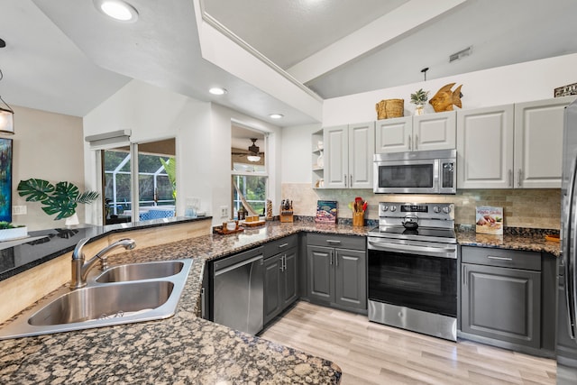 kitchen featuring appliances with stainless steel finishes, sink, lofted ceiling with beams, gray cabinets, and decorative backsplash