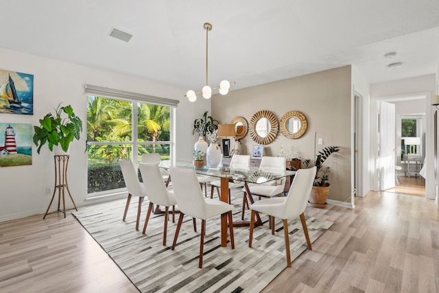 dining room featuring a notable chandelier and light wood-type flooring