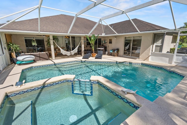 view of swimming pool featuring a patio, an in ground hot tub, and glass enclosure