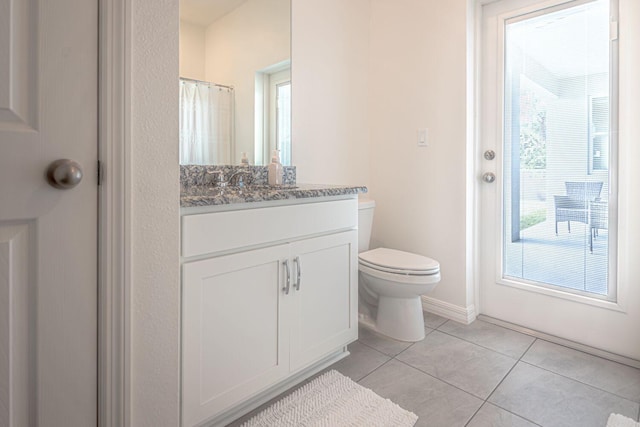 bathroom with tile patterned floors, a shower with curtain, vanity, and toilet