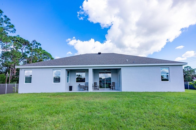 rear view of house featuring a yard and a patio