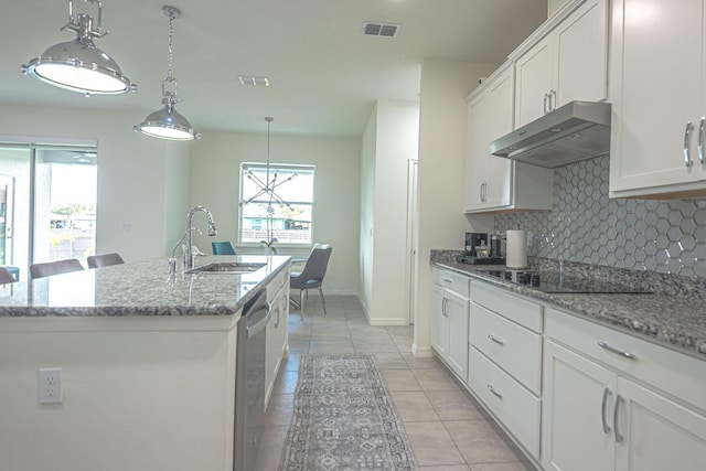 kitchen featuring white cabinets, black electric stovetop, sink, and an island with sink