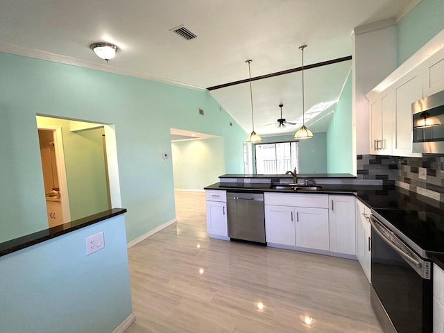 kitchen with lofted ceiling, sink, hanging light fixtures, appliances with stainless steel finishes, and white cabinetry