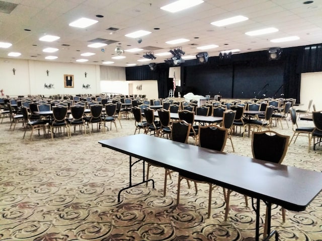 carpeted dining room featuring a paneled ceiling