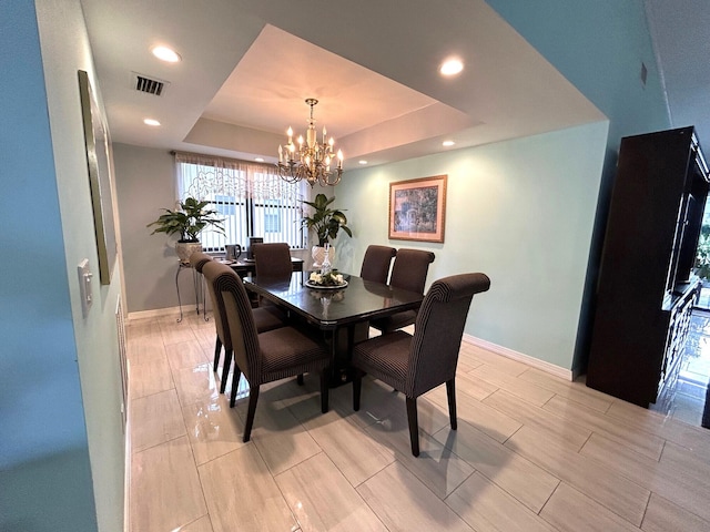 dining area featuring a tray ceiling and a notable chandelier