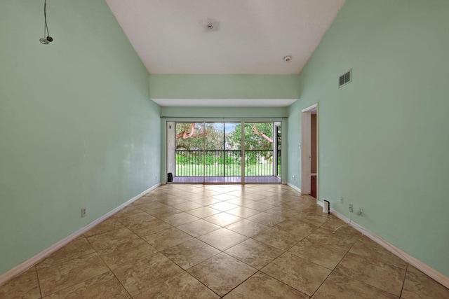 spare room featuring high vaulted ceiling and light tile patterned floors