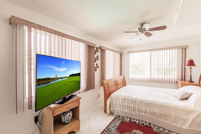 bedroom featuring a textured ceiling, ceiling fan, and light tile patterned flooring