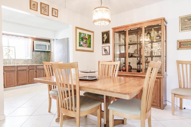 tiled dining area with sink and an inviting chandelier