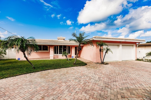 ranch-style home with a garage and a front lawn