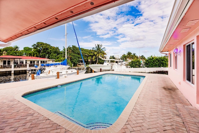 view of pool with a patio and a water view