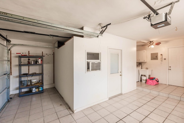 garage featuring electric panel, ceiling fan, and a garage door opener