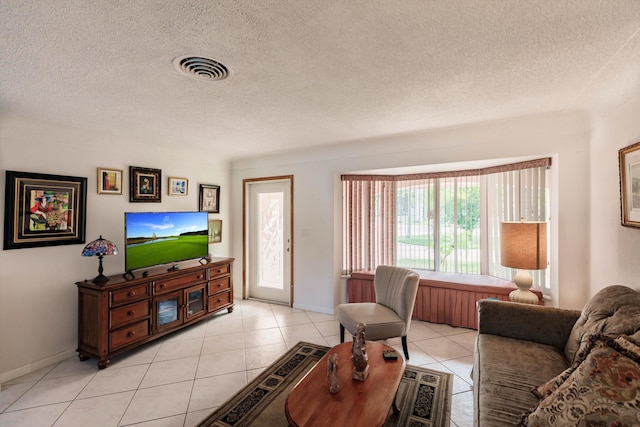 tiled living room featuring a textured ceiling