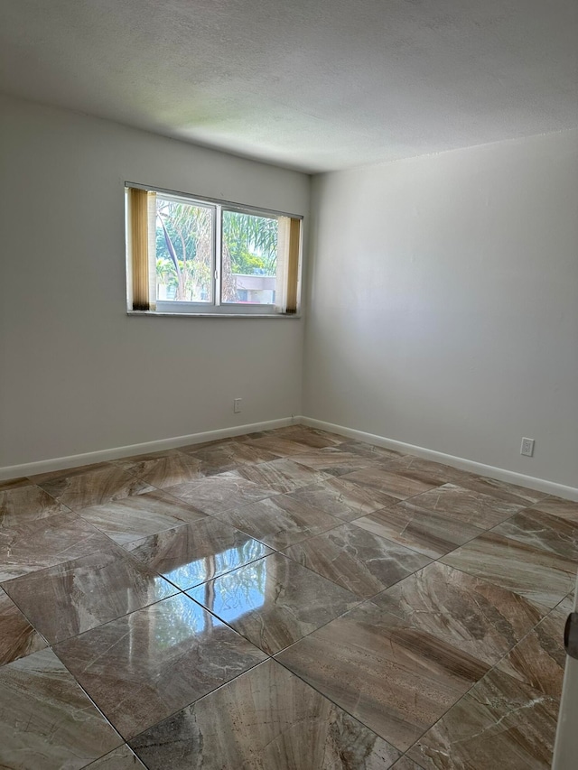 unfurnished room featuring a textured ceiling