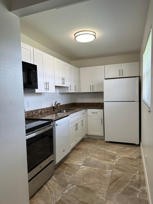 kitchen featuring white appliances, white cabinetry, and sink