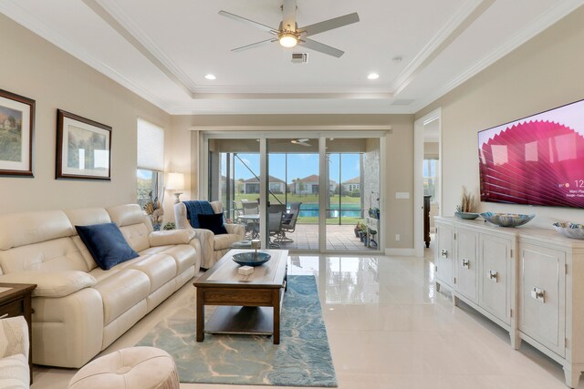 living room with ornamental molding, a tray ceiling, and ceiling fan