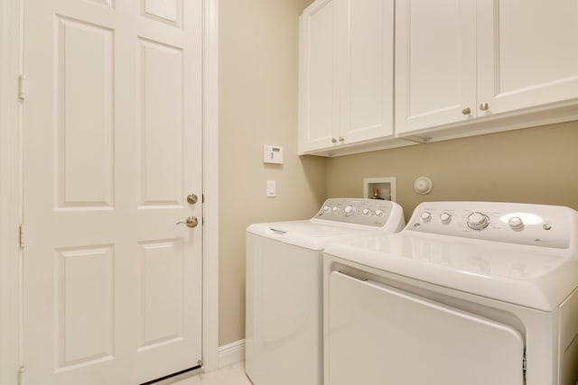 laundry area with independent washer and dryer and cabinets