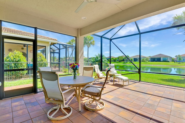 sunroom featuring a water view and ceiling fan