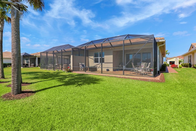 rear view of property featuring a patio, a lanai, a yard, and a swimming pool