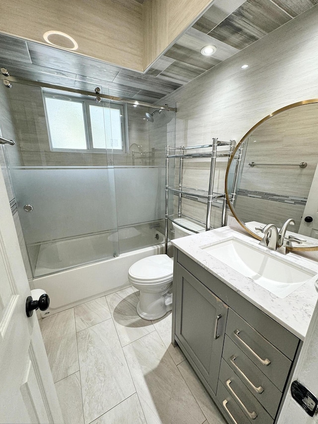 full bathroom featuring vanity, toilet, and combined bath / shower with glass door