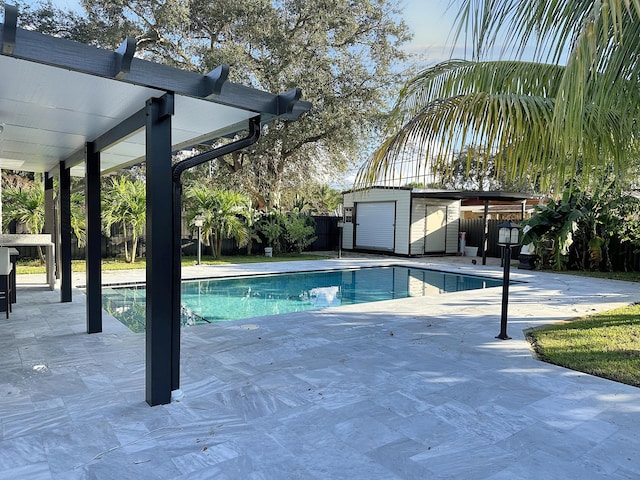 view of swimming pool featuring a patio and a storage shed