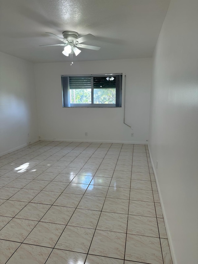 unfurnished room with a textured ceiling, light tile patterned floors, and ceiling fan