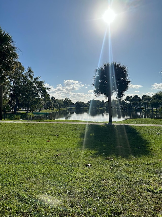 view of property's community with a water view and a yard