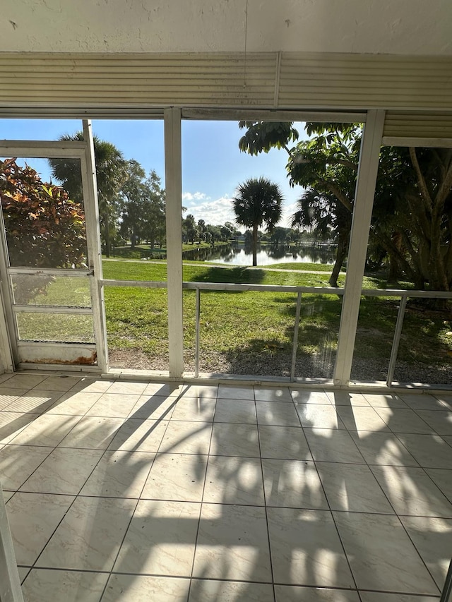 unfurnished sunroom featuring a water view and a healthy amount of sunlight