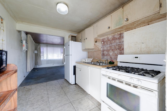 kitchen featuring white appliances, sink, white cabinets, crown molding, and light tile patterned floors