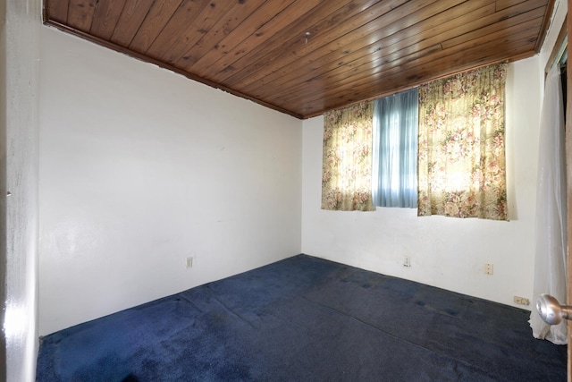 unfurnished room featuring ornamental molding, wooden ceiling, and dark carpet