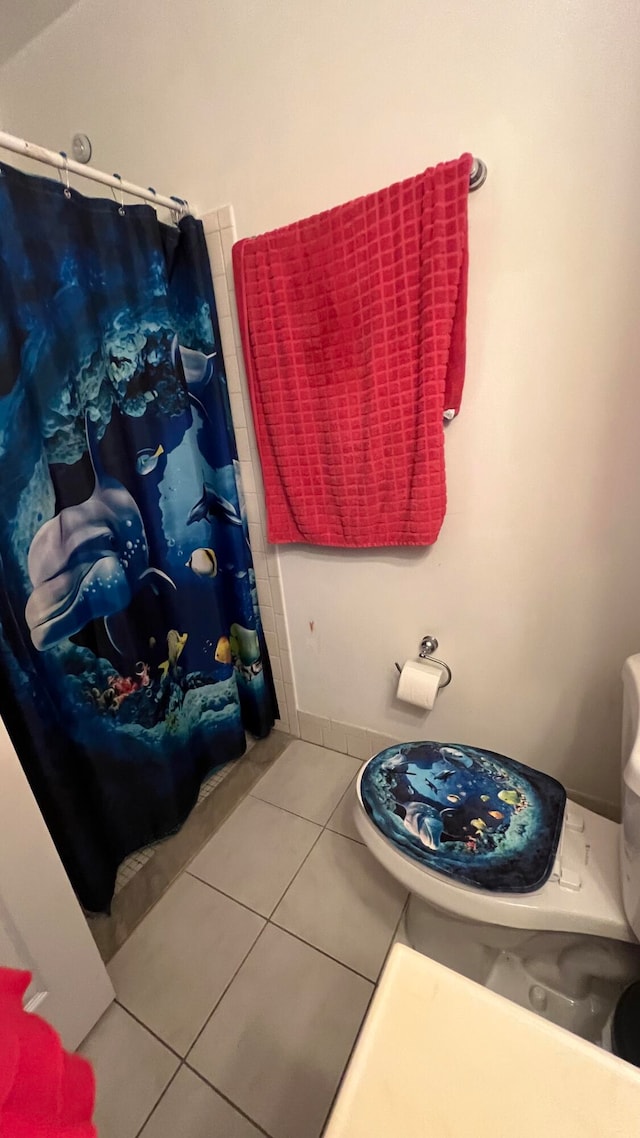 bathroom with toilet, tile patterned floors, and a shower with curtain