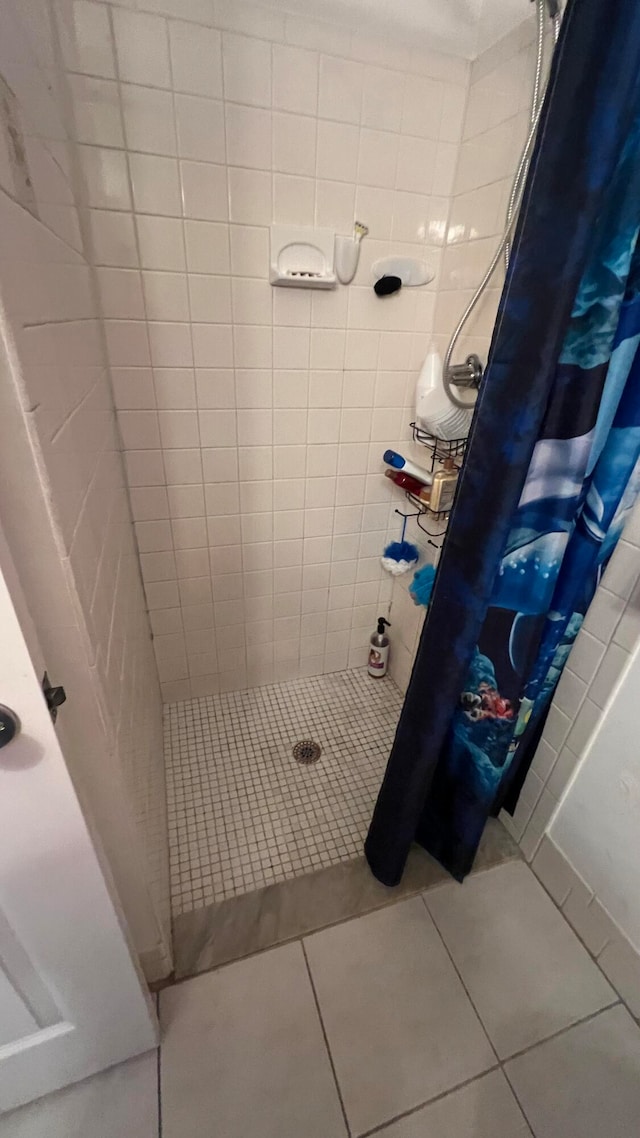 bathroom with walk in shower and tile patterned flooring